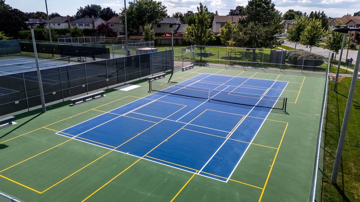 Terrains de pickleball au premier plan et terrains de tennis à l'arrière, tous en revêtement acrylique
